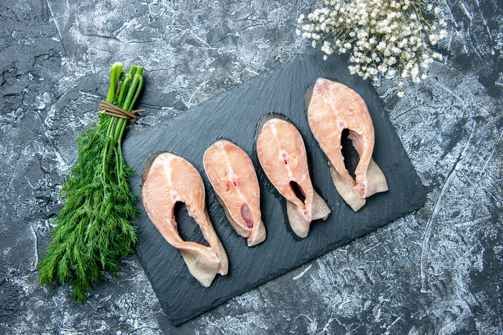 Top view of raw fish slices on black board