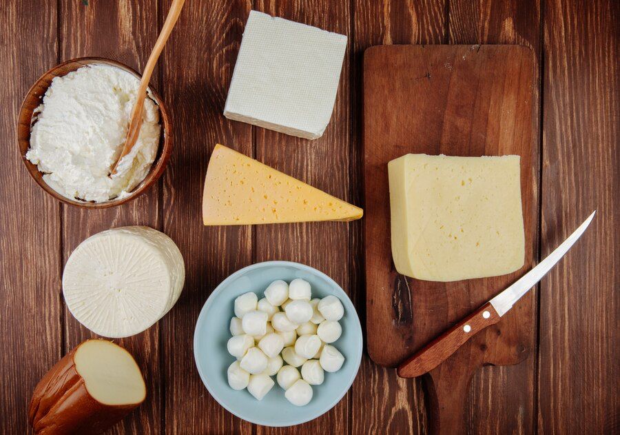 Top view of different kind of cheese on rustic wooden table